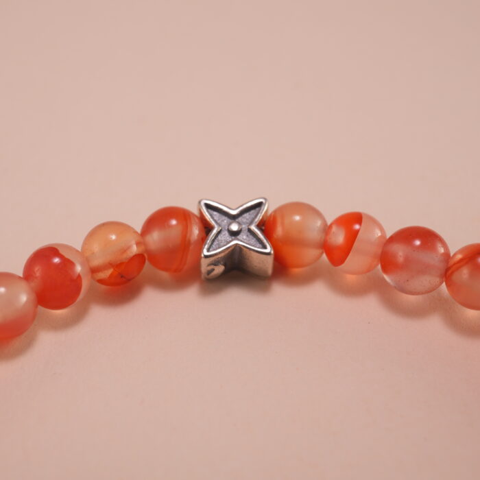 Close-up of carnelian beads and silver detailing on 4mm bracelet
