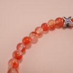 Close-up of carnelian beads and silver detailing on 4mm bracelet