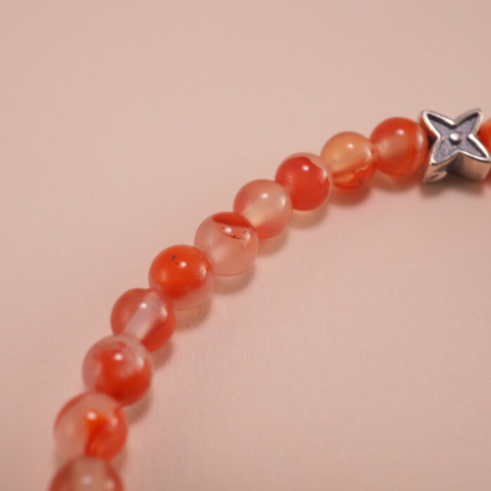 Close-up of carnelian beads and silver detailing on 4mm bracelet