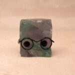 Natural Fluorite hedgehog figurine with multicolor tones on white background