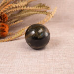 Labradorite crystal ball displayed on a desk.