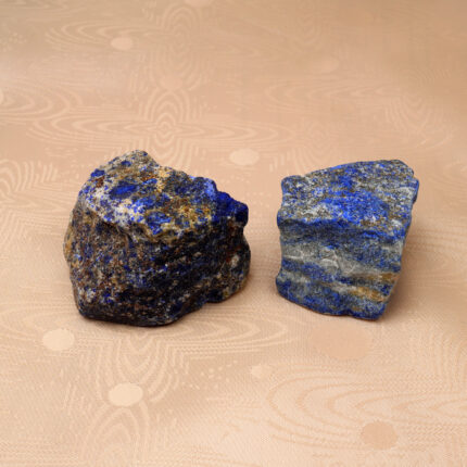 Natural Lapis Lazuli raw stone set displayed on a neutral background, showcasing its deep blue hues and unique texture.