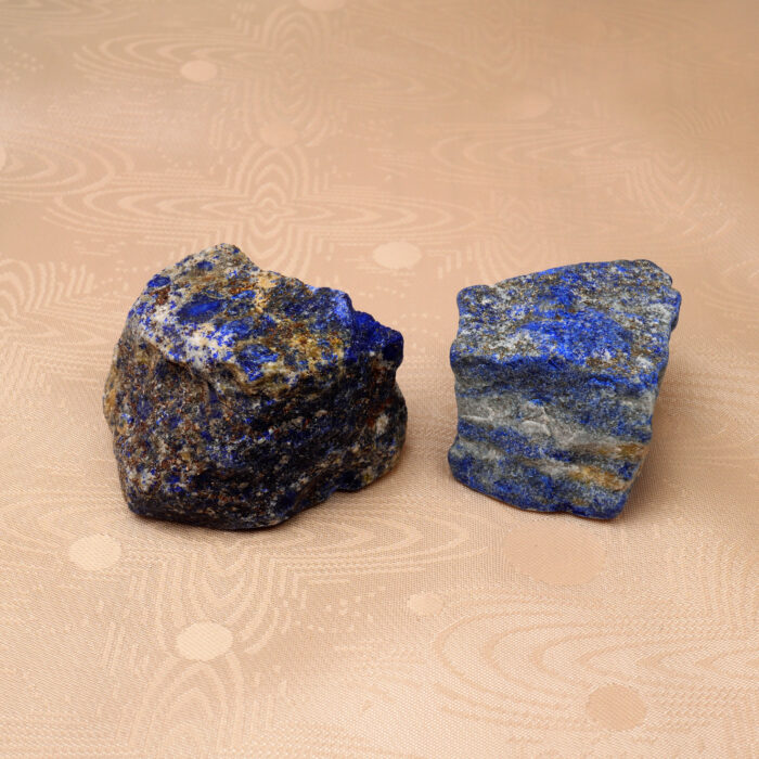 Natural Lapis Lazuli raw stone set displayed on a neutral background, showcasing its deep blue hues and unique texture.