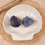 Lapis Lazuli raw stone set displayed in a natural setting, surrounded by plants or crystals for added aesthetic.