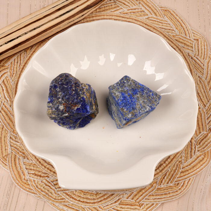 Lapis Lazuli raw stone set displayed in a natural setting, surrounded by plants or crystals for added aesthetic.