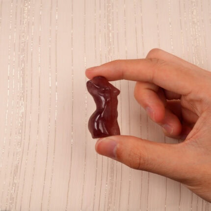 Hand holding a Natural Strawberry Quartz Model Figurine, showcasing its smooth texture and soft pink color