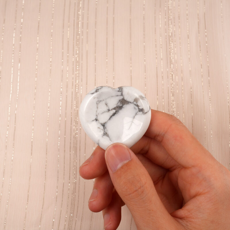 Hand holding a Howlite heart worry stone