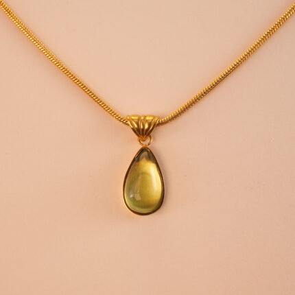 Close-up of faceted teardrop peridot stone with silver/gold setting