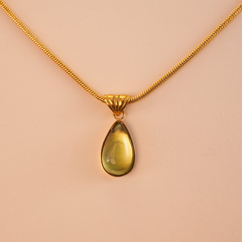 Close-up of faceted teardrop peridot stone with silver/gold setting