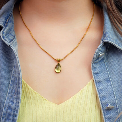 Model wearing the pendant, showing soft green glow at the collarbone