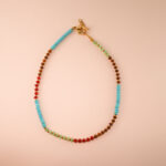 Handmade Tibetan turquoise, tiger eye and chalcedony necklace on white background