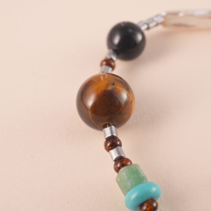Adjustable tiger eye and turquoise gemstone bracelet with braided cord on white background