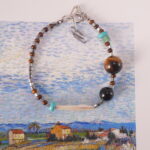 "Tiger eye and turquoise bracelet placed beside journal and crystals, ideal for meditation and daily energy rituals