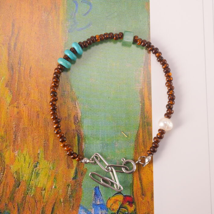 Flat lay of the Tiger Eye, Turquoise, and Pearl Bracelet, showcasing the natural gemstones and minimalist design on a serene background.
