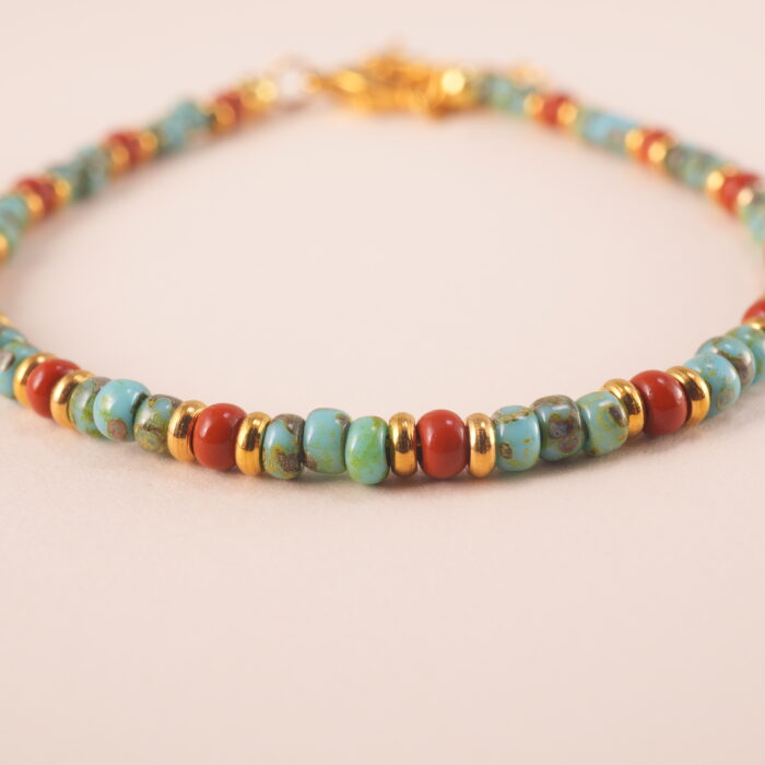 Close-up of turquoise and red agate beads with elastic cord and polished finish
