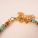 Close-up of turquoise and red agate beads with elastic cord and polished finish