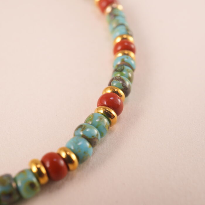 Close-up of turquoise and red agate beads with elastic cord and polished finish