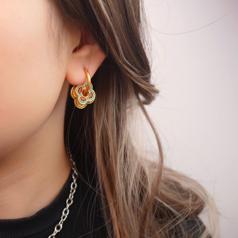 Model wearing the hoop earrings, showing vibrant color and floral charm
