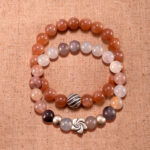 Main image showing stacked peach moonstone and aventurine S925 bracelets.