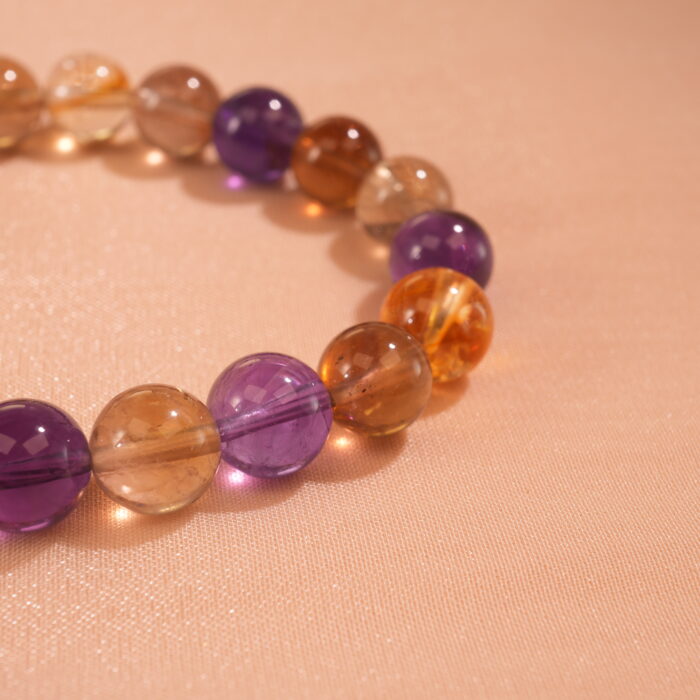 Close-up of ametrine bracelet featuring blended purple and yellow crystal beads.（紫黄晶手串特写）