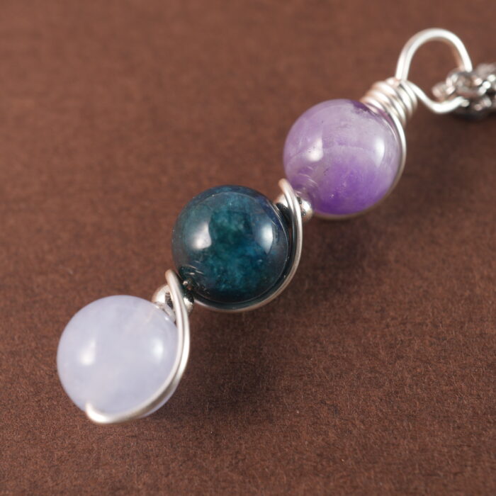 Close-up of Aquarius necklace showing amethyst, blue apatite, and aquamarine beads.