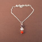Aries zodiac necklace with amethyst, clear quartz, and red agate gemstones.