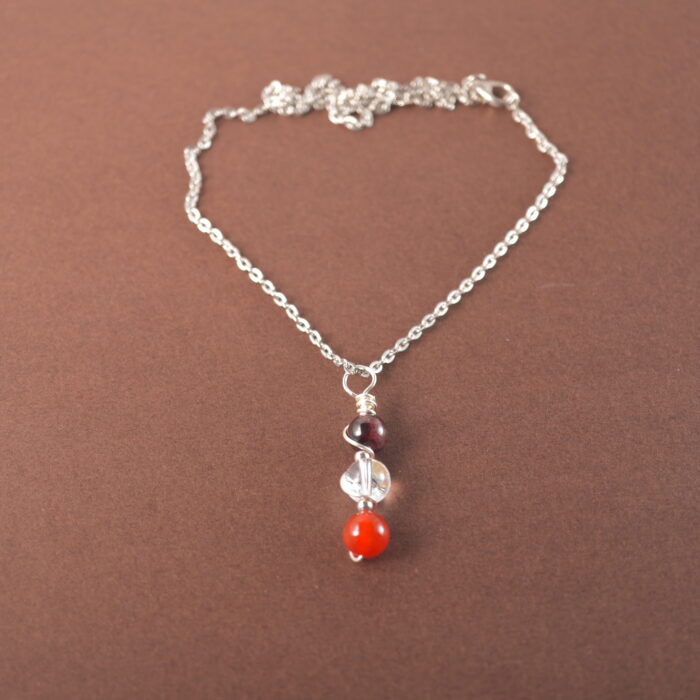 Aries zodiac necklace with amethyst, clear quartz, and red agate gemstones.