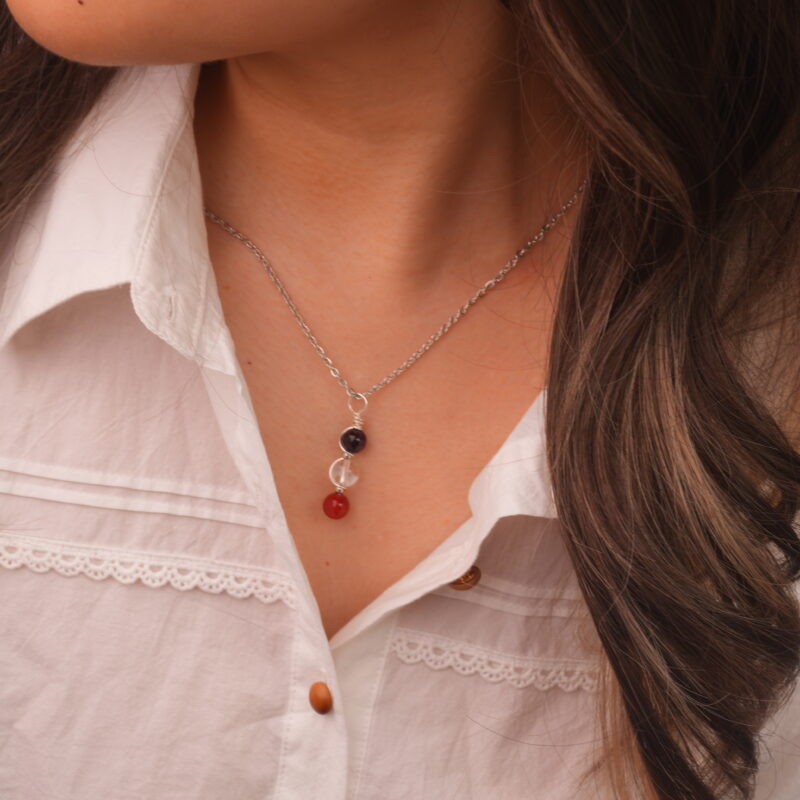 Model wearing Aries zodiac necklace with amethyst, clear quartz, and red agate.