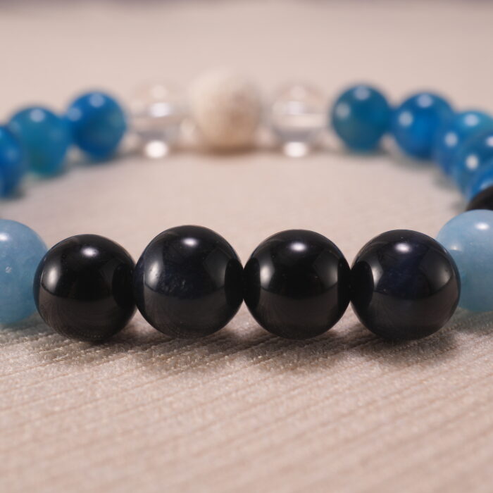 Close-up of blue apatite, obsidian, and quartz bracelet with lava stone.
