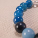 Close-up of blue apatite, obsidian, and quartz bracelet with lava stone.