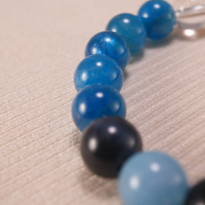 Close-up of blue apatite, obsidian, and quartz bracelet with lava stone.