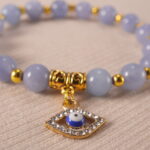 Close-up of blue chalcedony evil eye bracelet with glossy beads.