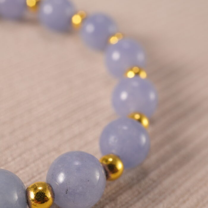 Close-up of blue chalcedony evil eye bracelet with glossy beads.