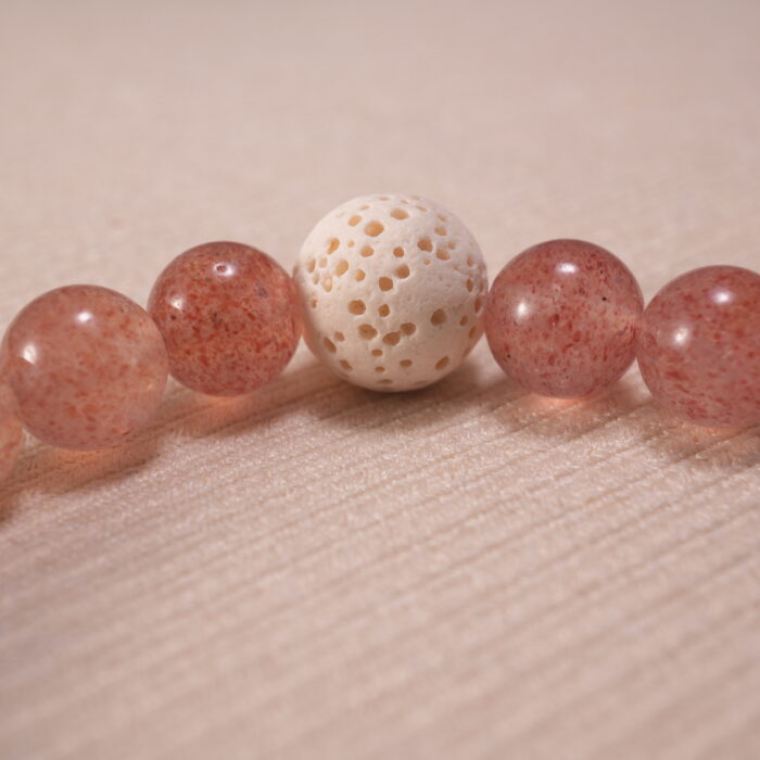 Close-up of blue chalcedony bracelet with strawberry quartz and lava.