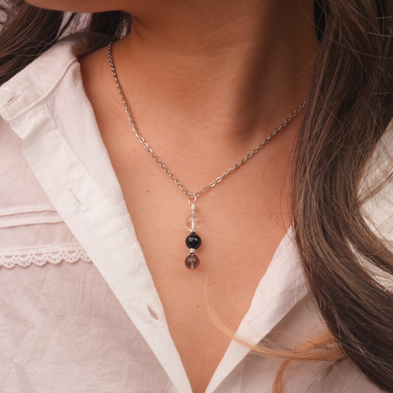 Model wearing Capricorn zodiac necklace with clear quartz, obsidian, and smoky quartz.