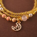 Close-up of polished Citrine and White Chalcedony beads with metal accents.