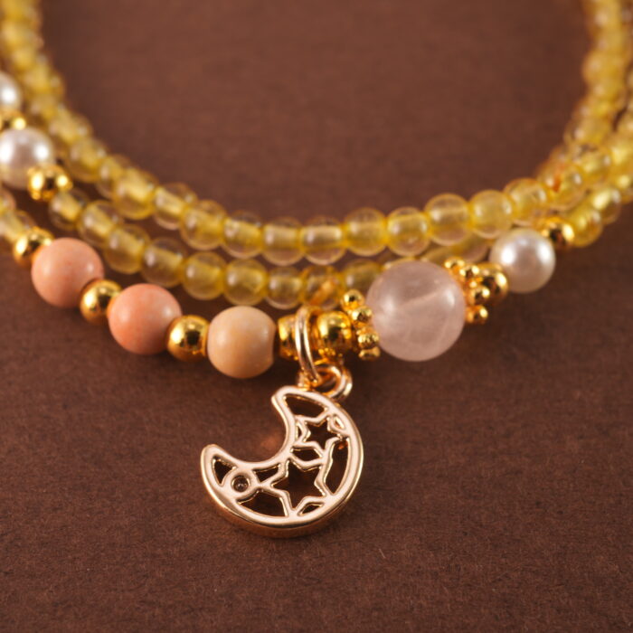 Close-up of polished Citrine and White Chalcedony beads with metal accents.