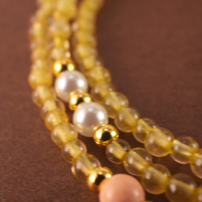 Close-up of polished Citrine and White Chalcedony beads with metal accents.