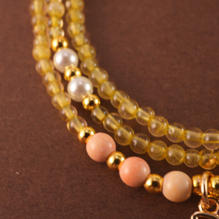 Close-up of polished Citrine and White Chalcedony beads with metal accents.