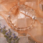 Clear quartz bracelet placed in natural light with soft white setting.