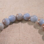 Close-up of cream chalcedony bracelet with smooth warm beige tones.
