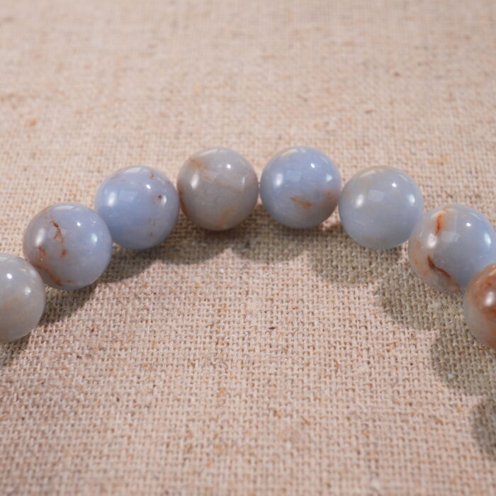 Close-up of cream chalcedony bracelet with smooth warm beige tones.