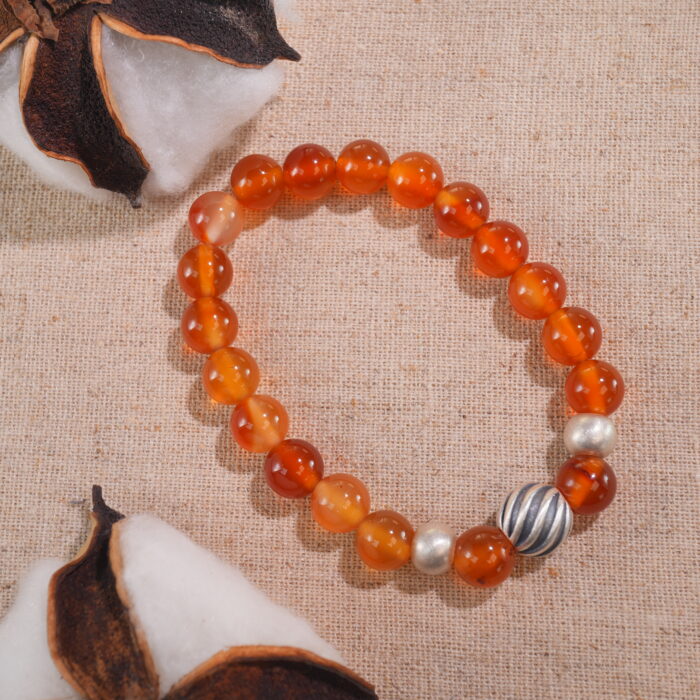 Flatlay of second flower red agate bracelet placed in minimal setup.
