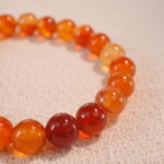 Close-up of flower red agate bracelet with marbled red tones.