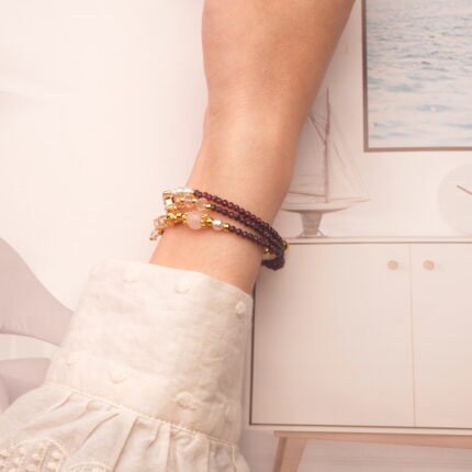 Model showcases the garnet piece worn as a bracelet, emphasizing its elegant wrap style.