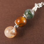 Close-up of Gemini necklace showing moss agate, tiger eye, and citrine beads.