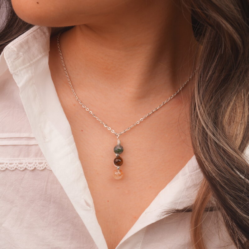 Model wearing Gemini zodiac necklace with moss agate, tiger eye, and citrine.