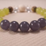 Close-up of gray agate bracelet with quartz and lava accents.