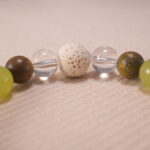 Close-up of gray agate bracelet with quartz and lava accents.