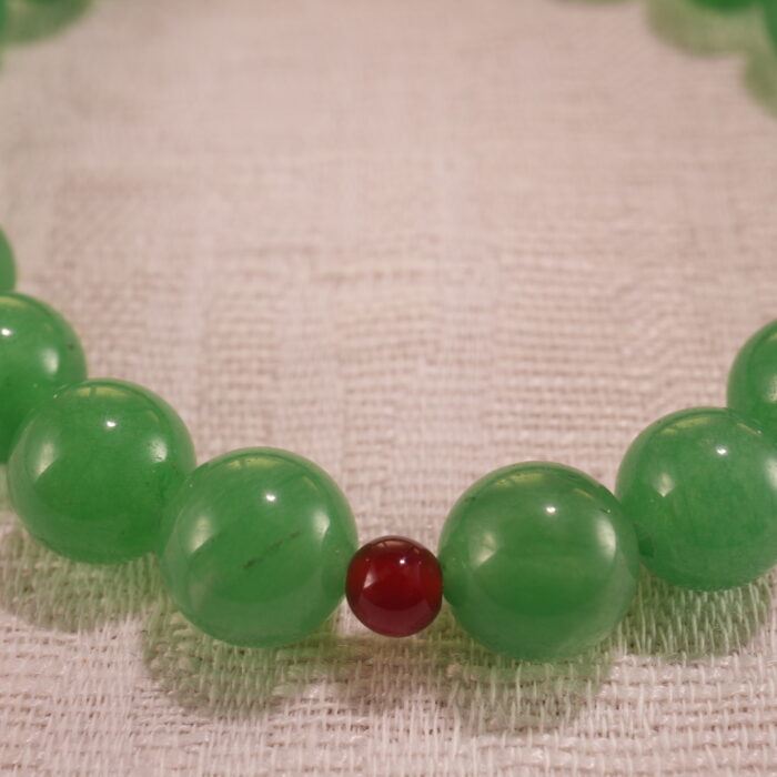 Close-up of bracelet combining green aventurine and red agate beads.